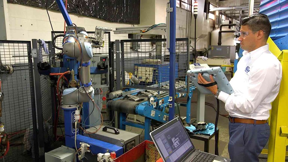Man programming collaborative robot for welding application