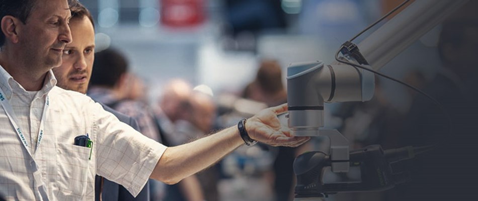 Man in white shirt touches collaborative robot